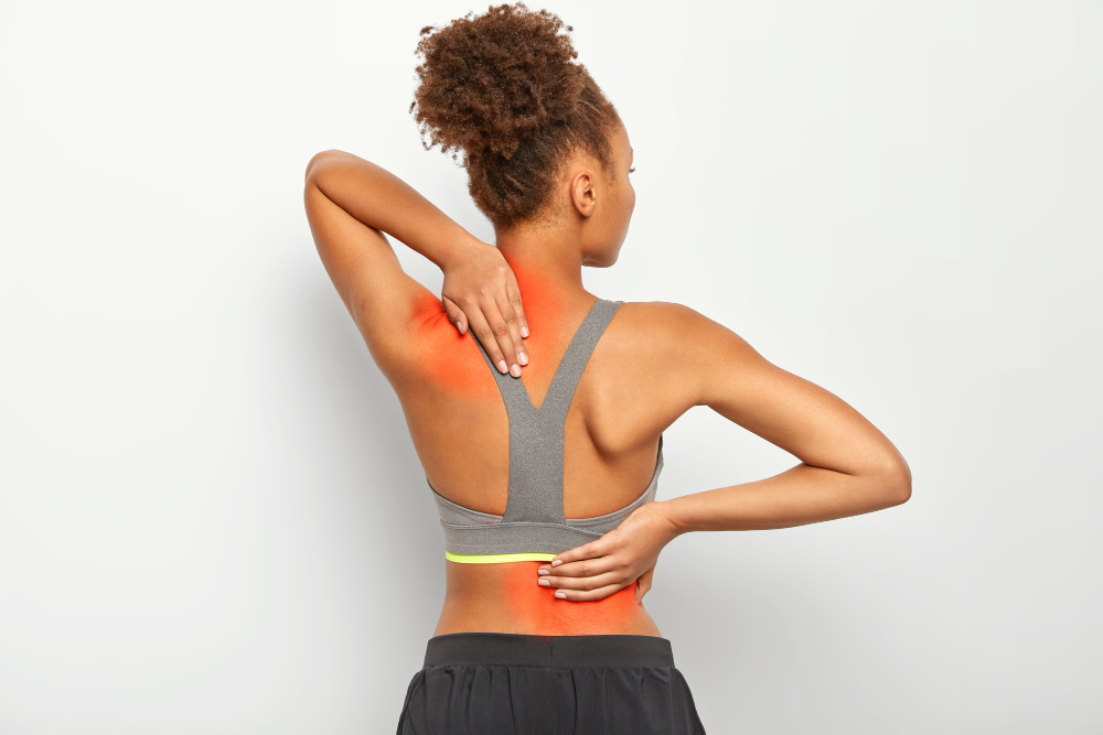 faceless-curly-woman-suffers-from-spine-pain-wears-sport-bra-shows-location-of-inflammation-isolated-on-white-background
